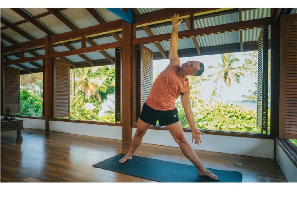 Man in yoga studio doing Triangle Yoga Pose at Blue Osa