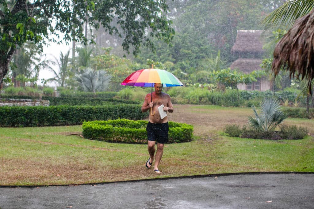 man walking under a umbrella in the rain in costa rica