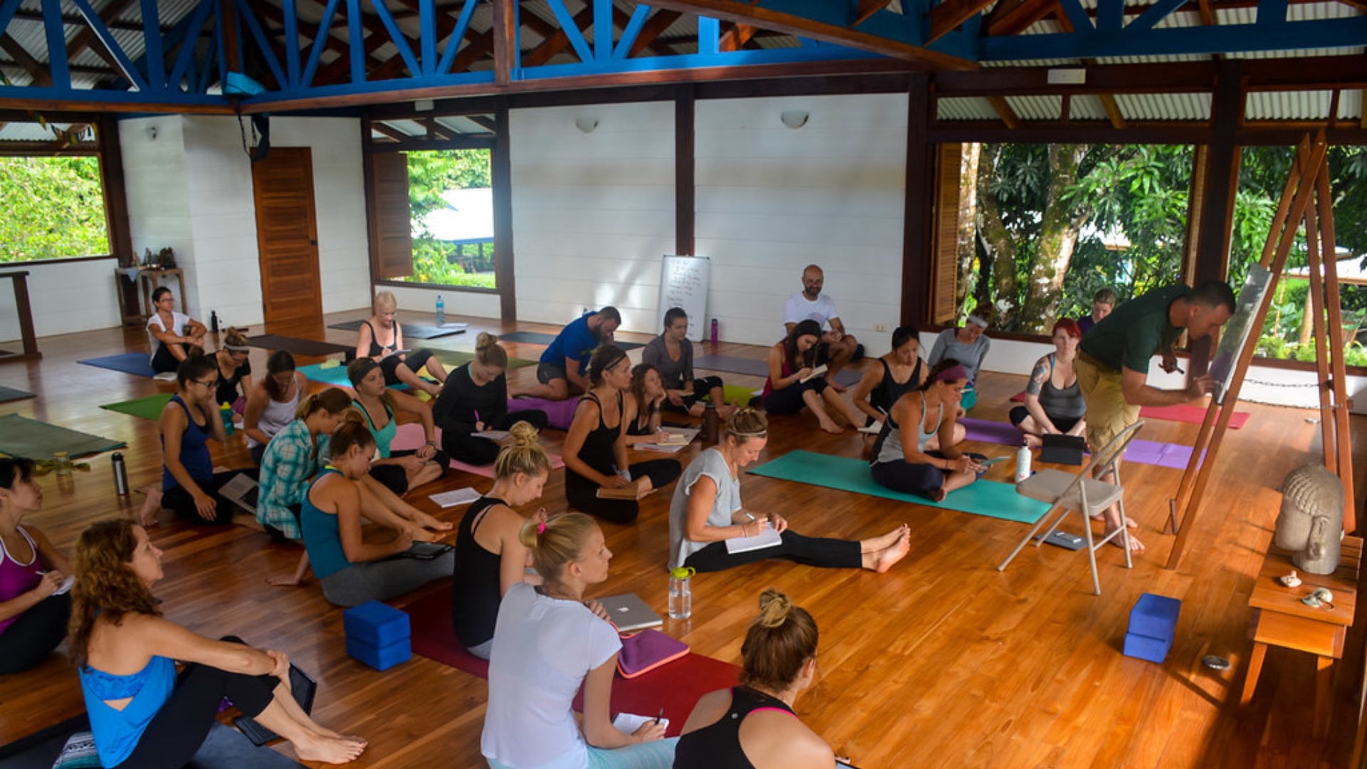 Yoga students sitting on their mats during a YTT in Blue Osa's yoga shala in Costa Rica.