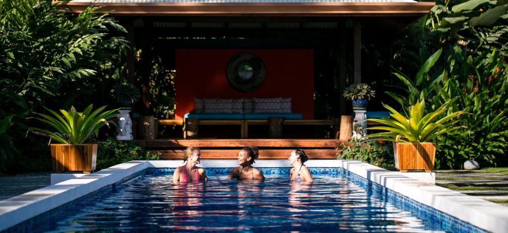 Yoga teacher training students relaxing together in the Blue Osa lap pool in Costa Rica