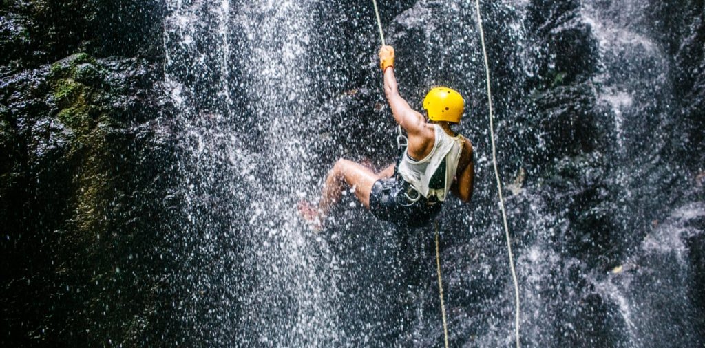 Man repelling down a waterfall on Blue Osa Yoga Retreat & Spa Horseback riding and water repelling waterfall eco-adventure in Costa Rica adventure retreat