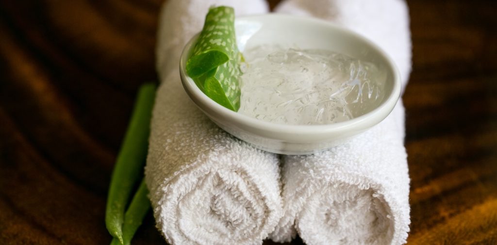 4 rolled up white towels with a small bowl of aloe vera. DIY body scrubs