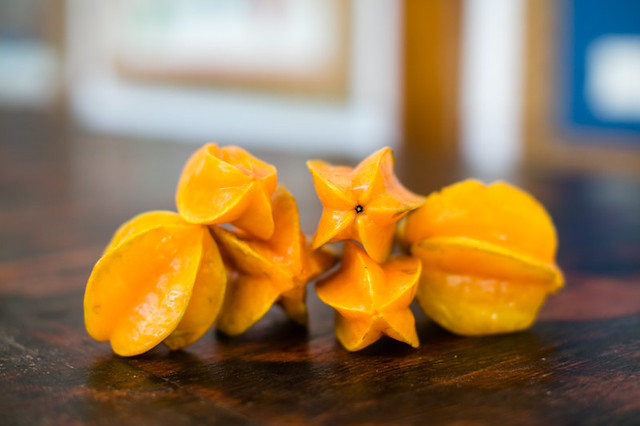 Six starfruits piled on a wooden table showing off their star shape at Blue Osa in Costa Rica. 