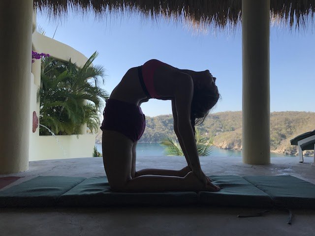 woman practicing Iyengar yoga in camel pose