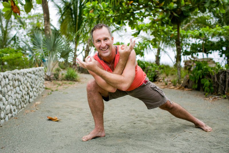 Yogi Aaron practicing a side lunge pose on the beach at Blue Osa in Costa Rica. 