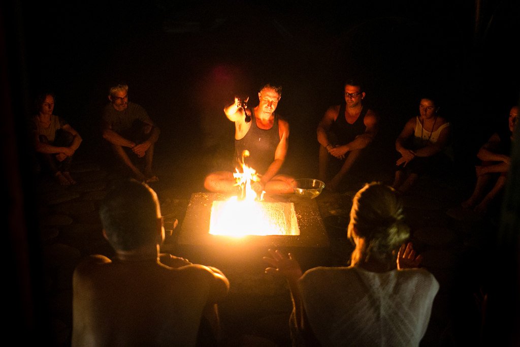 Yogi Aaron performing a ritual over a fire surrounded by yoga students at Blue Osa in Costa Rica. 