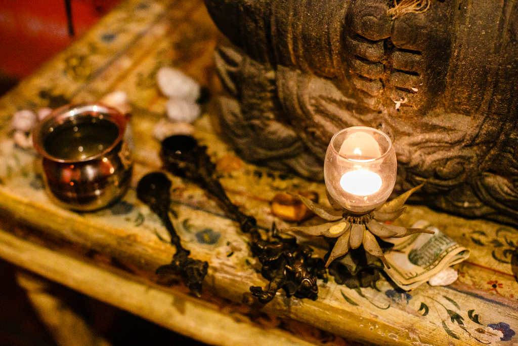 Lit candles and monetary offerings sitting on Ganesh's alter in Blue Osa's meditation temple in Costa Rica. 