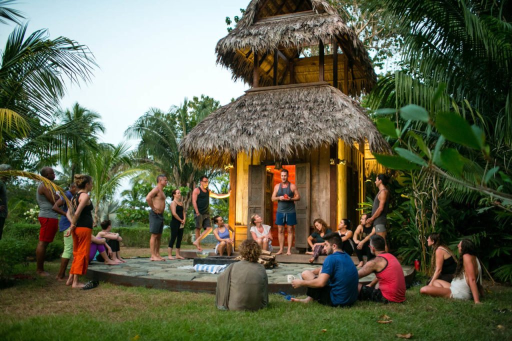 Yogi Aaron standing outside Blue Osa's meditation temple teaching a group of yoga students in Costa Rica. 