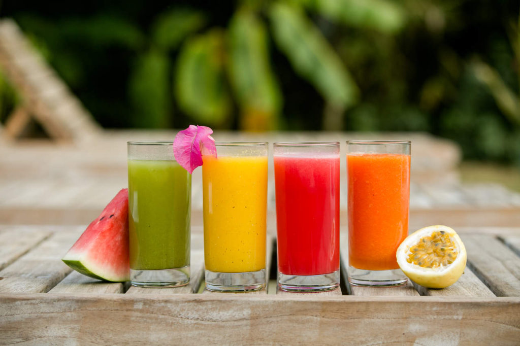 a display of many colors of natural juices