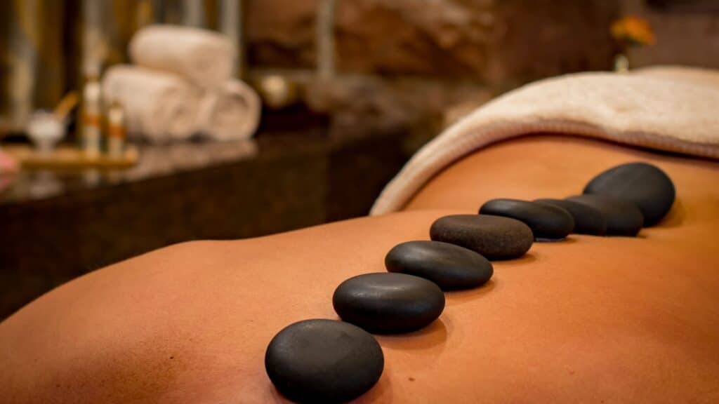 Woman lying on her stomach with hot stones on her back during a spa treatment at Blue Osa in Costa Rica.