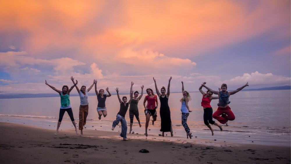 Costa Rica yoga retreat guests celebrating at sunset on Blue Osa beach Costa Rica yoga retreat guests celebrating at sunset on Blue Osa beach