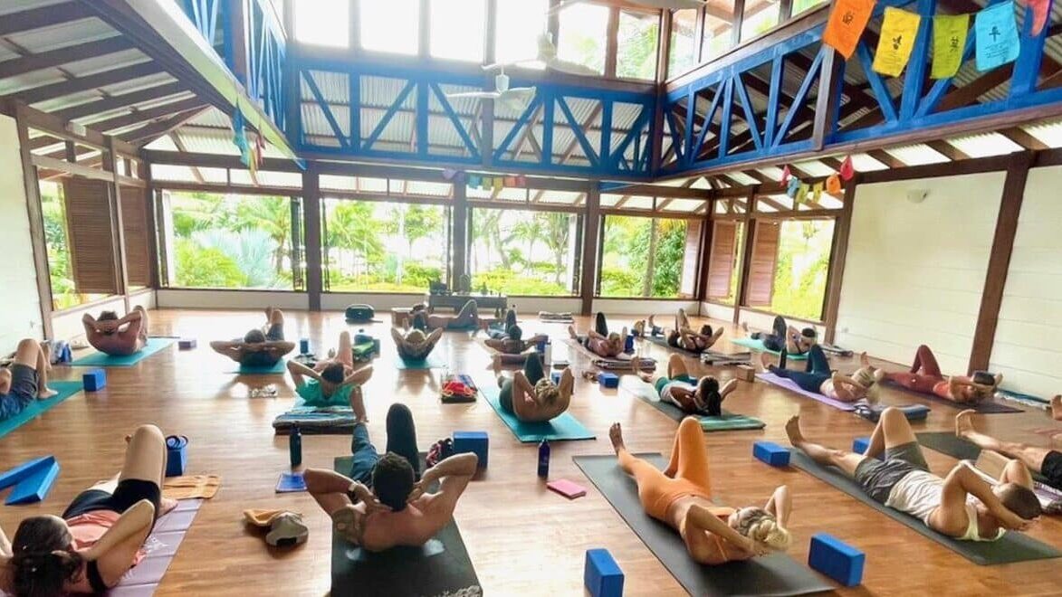 Yoga students doing abdominal exercises on the floor of Blue Osa's yoga shala in Costa Rica. 