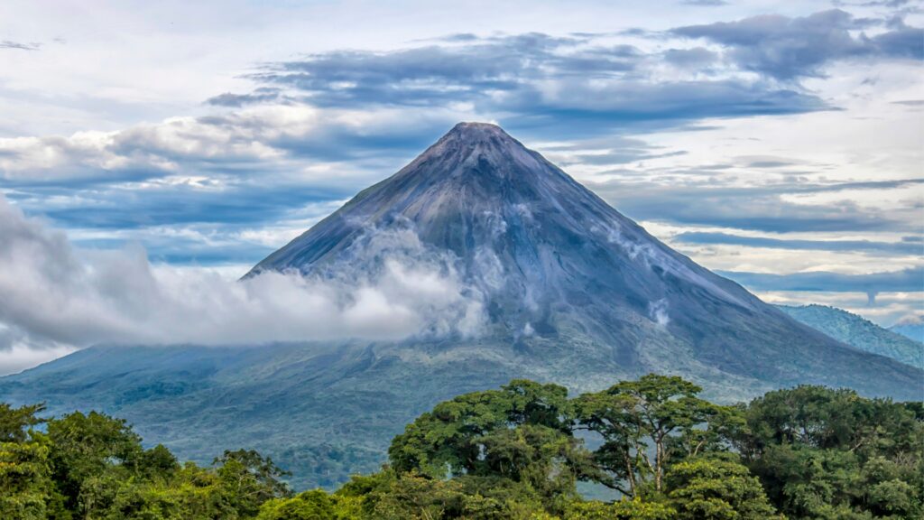 Arenal Volcano surrounded by clouds and jungle in Costa Rica. 