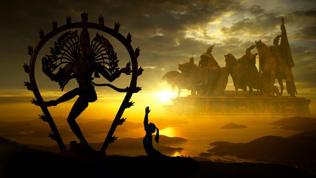 Statue of Hindu diety with a woman worshipping in a yoga pose in front. Sunset over the water with other statues of Hindu dieties in the background. 