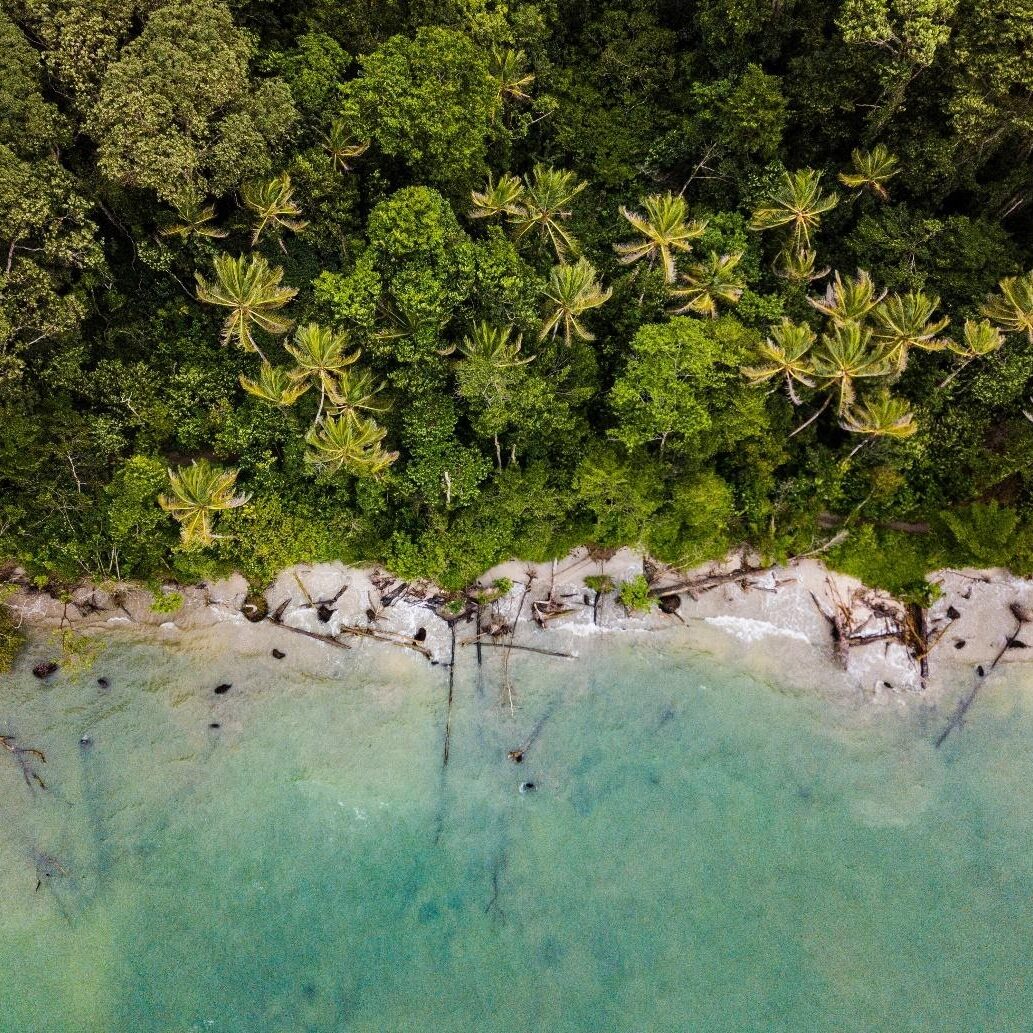 Aerial view of a beach in Costa Rica of turquoise blue water, sand and jungle. 