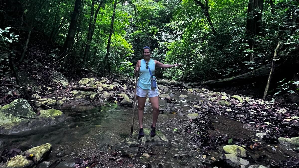 Carly standing in a creek in the jungle on her hike to a waterfall in Costa Rica. 