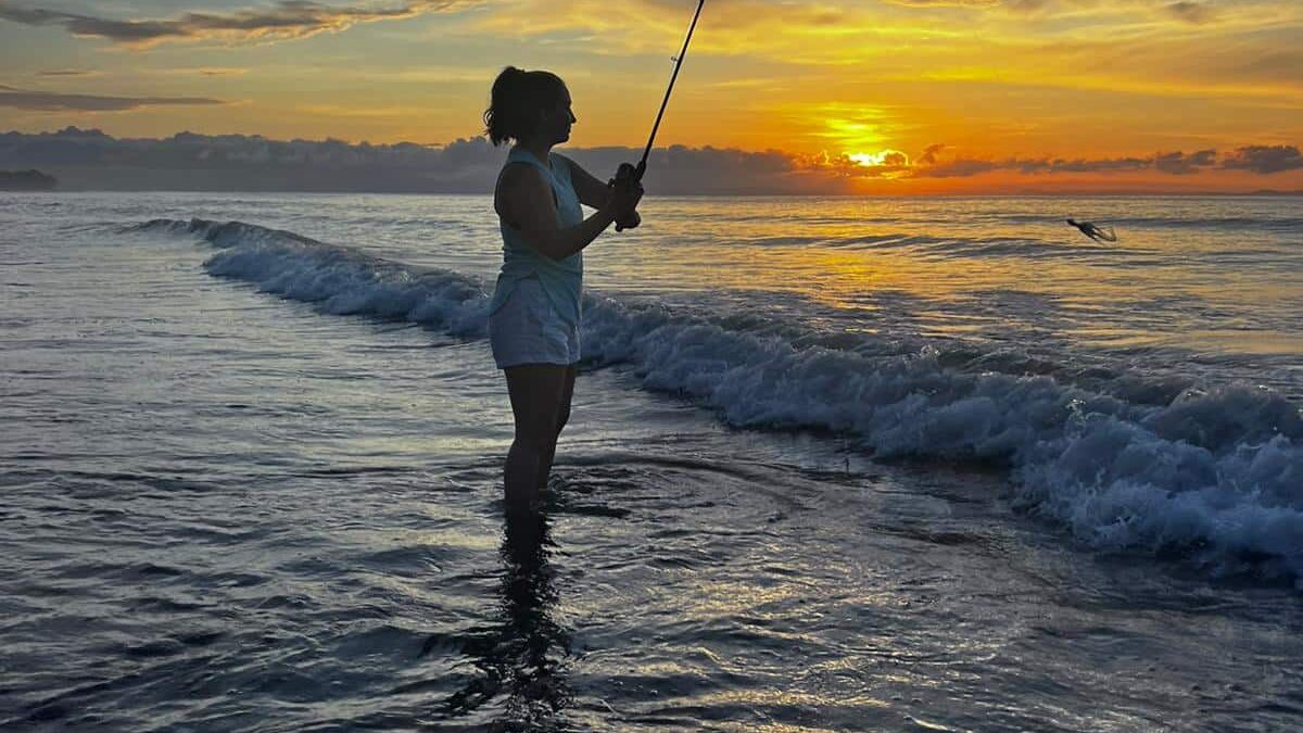 Carly fishing during sunrise on the beach at Blue Osa in Costa Rica.