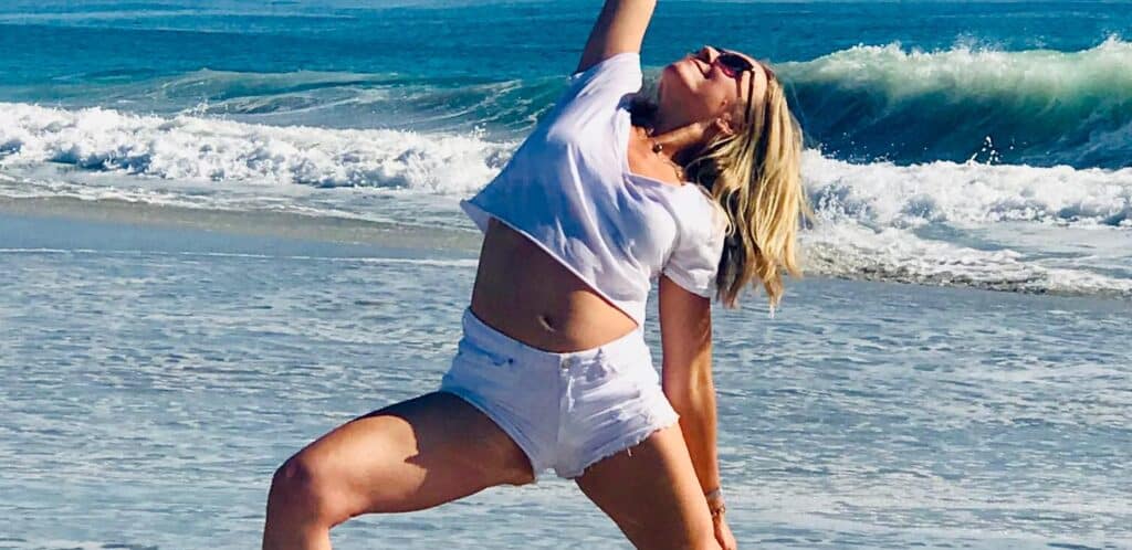 woman doing a yoga pose on the beach in costa rica