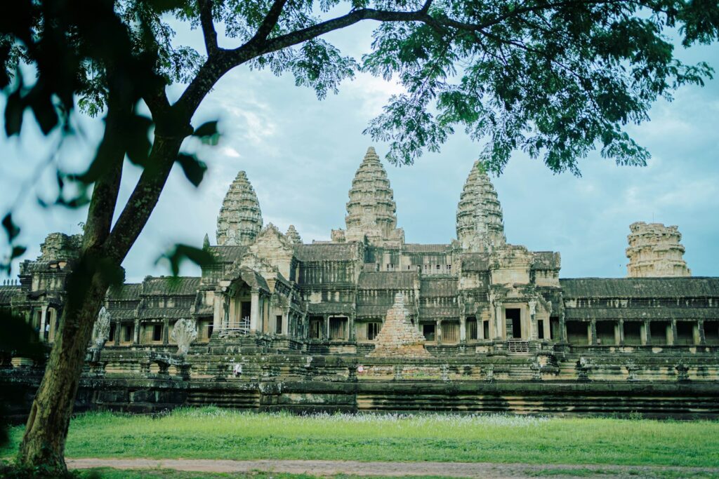 revealing the secrets of angkor wat | a large stone building with a tree in front of it