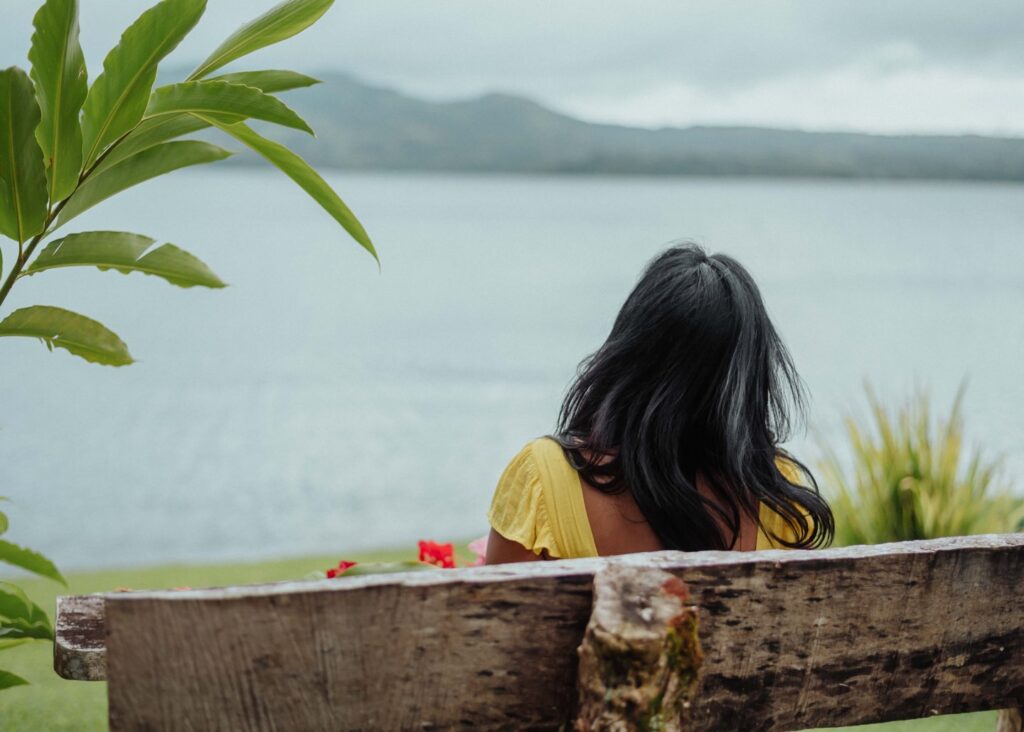 Student in quiet reflection overlooking the ocean during a two week yoga teacher training immersion at Blue Osa