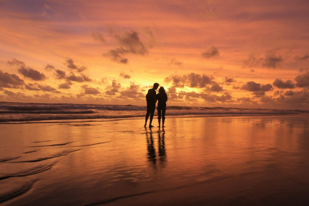 Couple silhouetted at sunset on Blue Osa beach Costa Rica psilocybin retreat for relationship healing