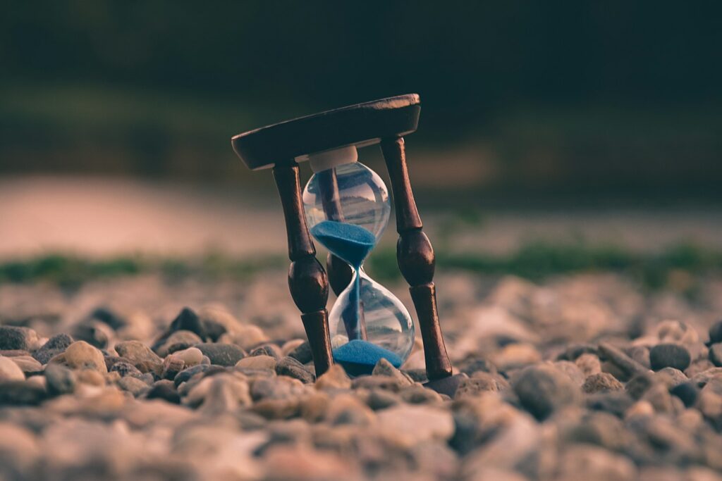 selective focus photo of brown and blue hourglass on stones should I take a yoga teacher training is a yoga teacher training worth it