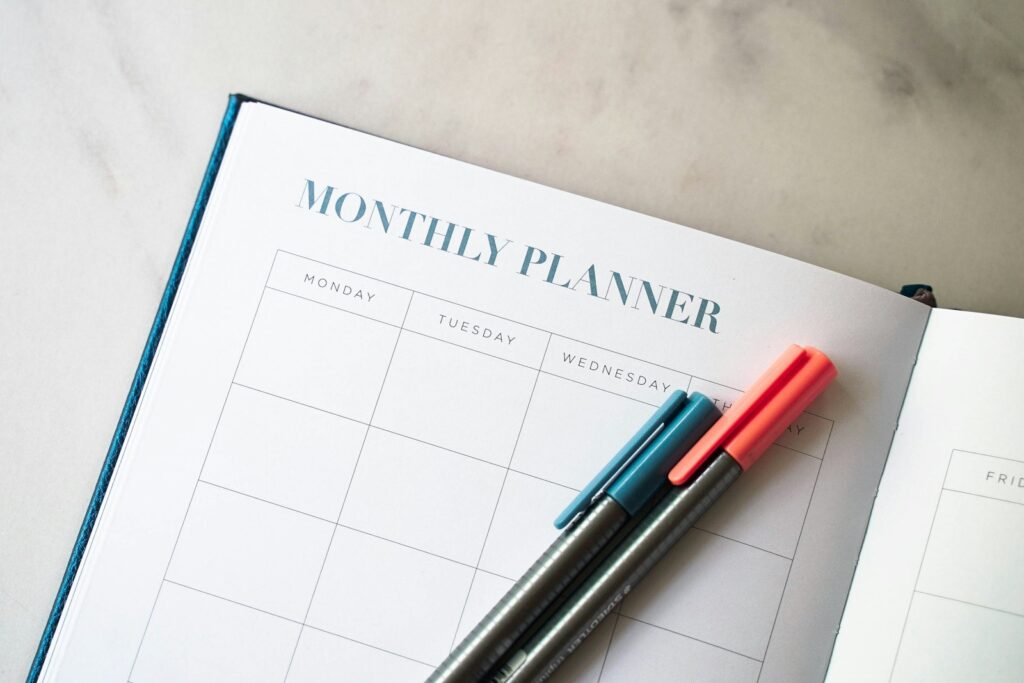 a planner with two pens sitting on top of it calendar planning working vacation