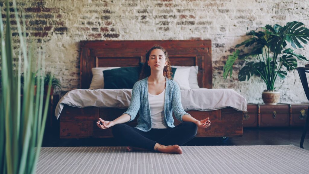 Woman meditating cross-legged on the floor
home yoga practice