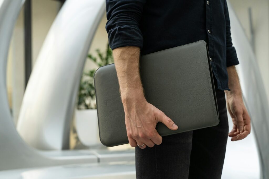 a man holding a laptop in his hand zipped in secure case for working on vacation